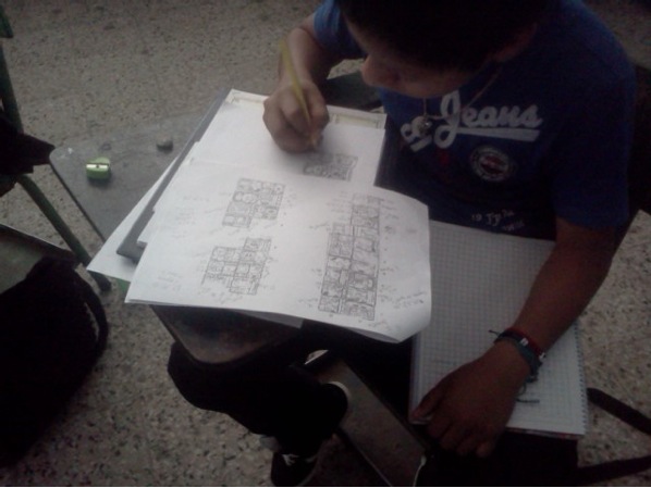 Junajpu Santos, estudiante Poqomam, elaborando su texto en papel antes de escribirlo en cerámica.