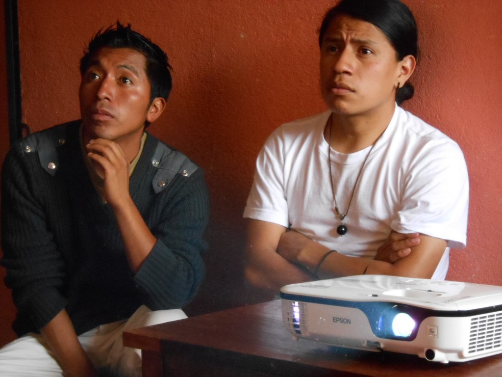 Rony López (left, Maya Mam), and Walter Amilcar (Maya Kaqchikel), watch the presentation by Hector, given on their brand new Epson digital projector, donated by MAM supporters for exactly this kind of purpose.
