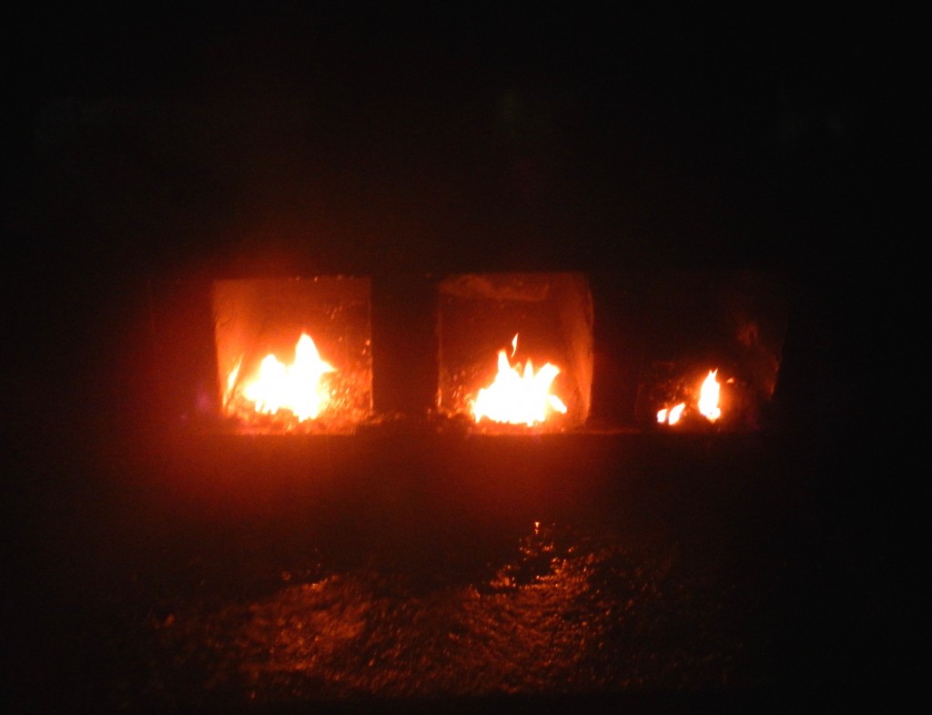 Fire at the base of “cruz de costumbre,” a memorial to ancestors and history. 