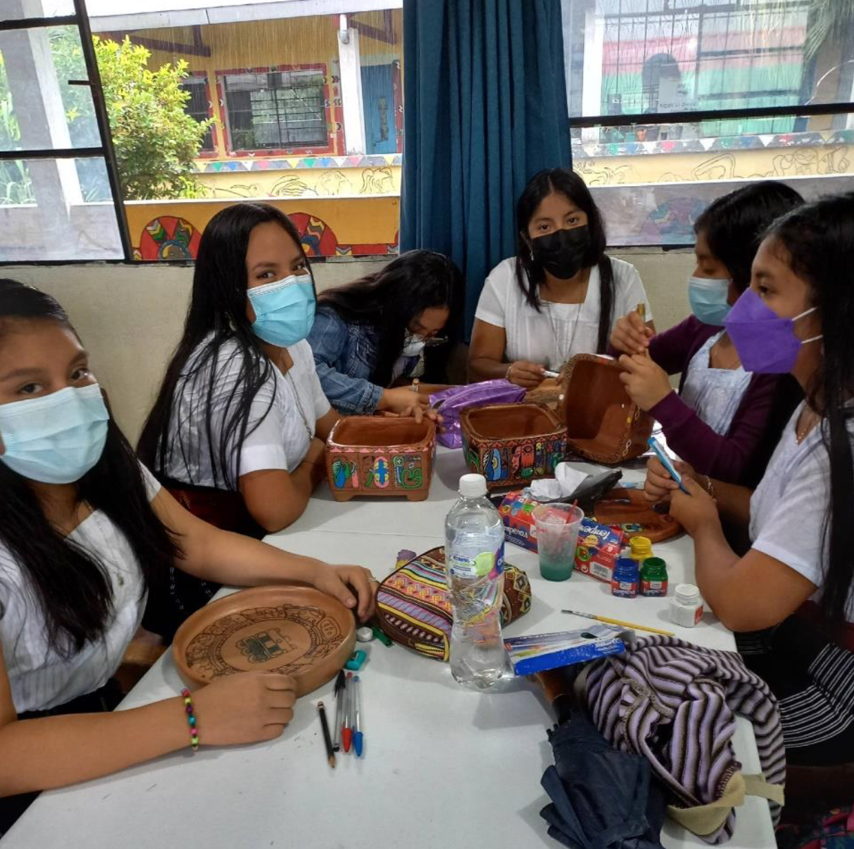 A group of people sitting at a table with masks on

Description automatically generated with low confidence