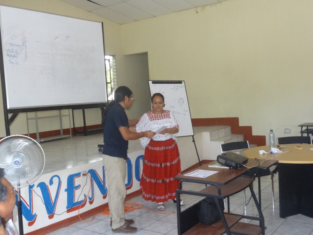 Hector Xol, workshop facilitator, delivering a certificate of participation to one of the participating teachers.