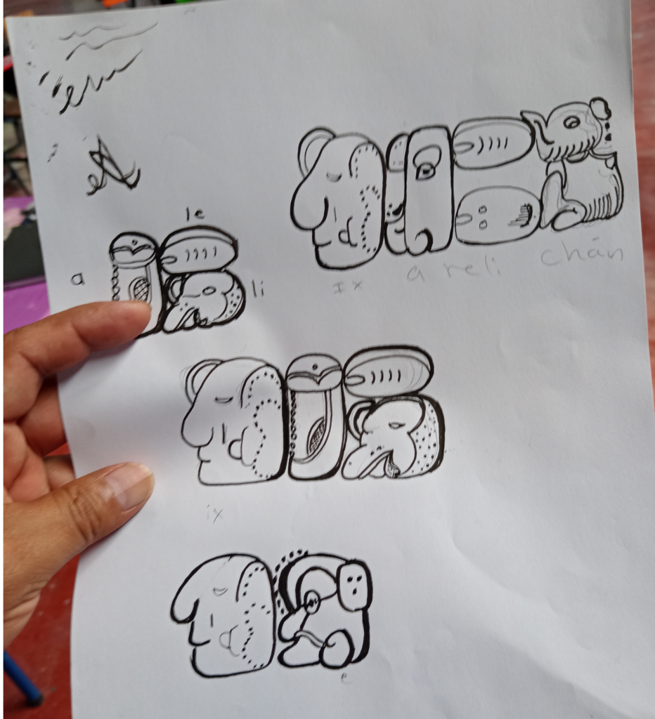 A hand holding a piece of paper with drawings Description automatically generated