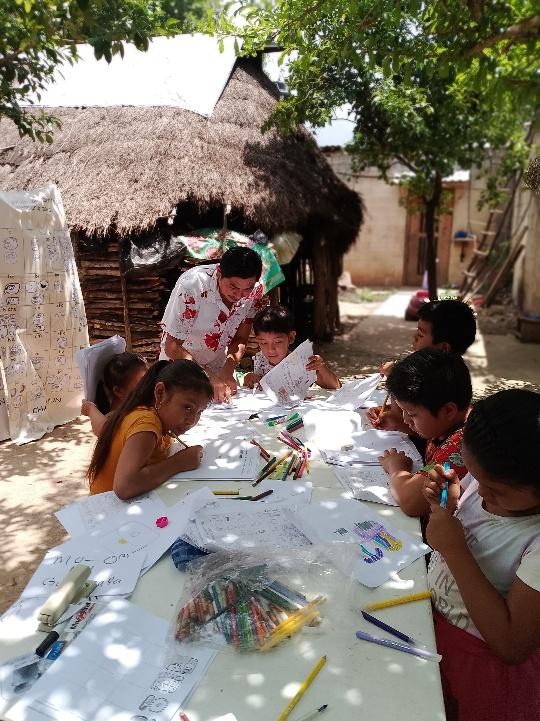 A group of children drawing on paper

Description automatically generated