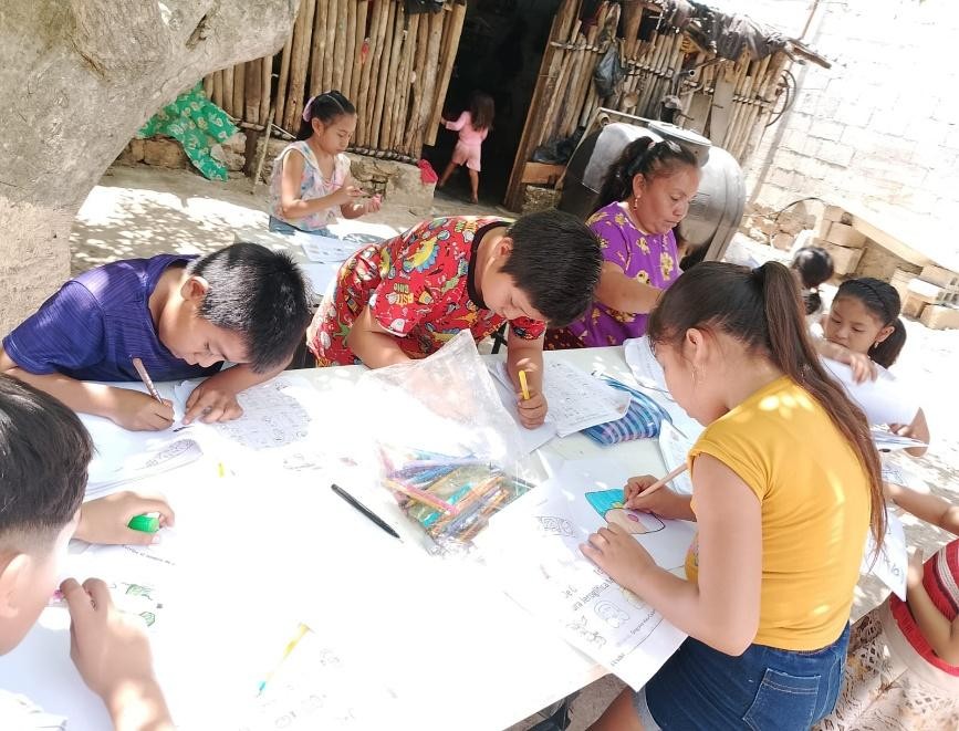 A group of children drawing on paper

Description automatically generated