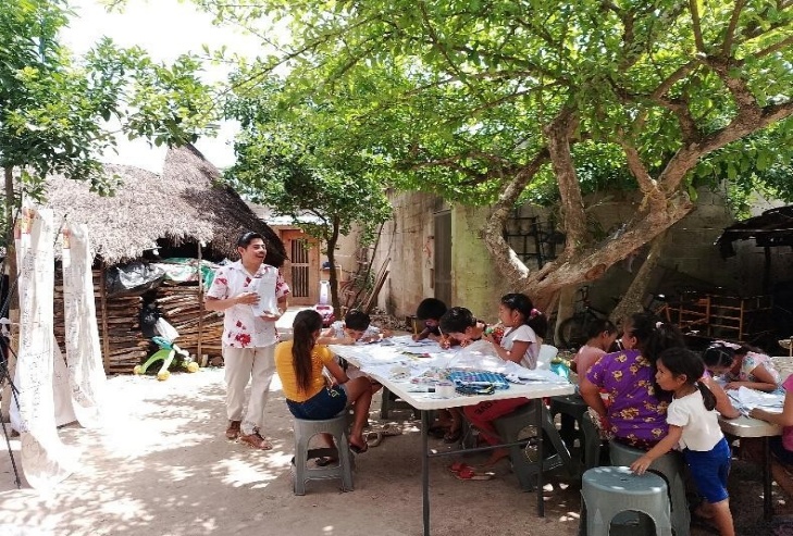 A group of children sitting around a table

Description automatically generated