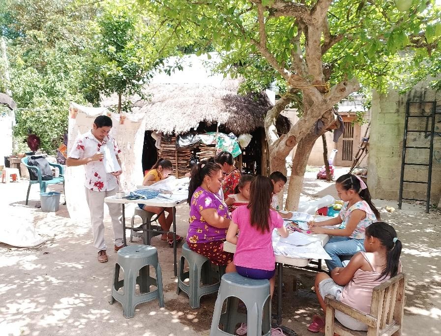 A group of people sitting at tables outside

Description automatically generated