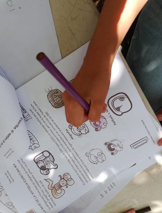 A person holding a pencil over a piece of paper

Description automatically generated